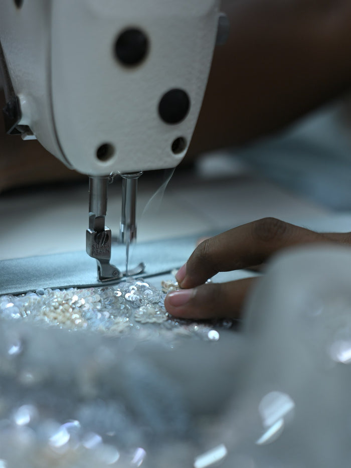 A sewing machine needle running along a hand-beaded panel