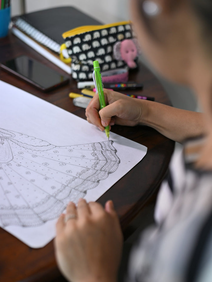 A designer sketching a lehenga in the studio
