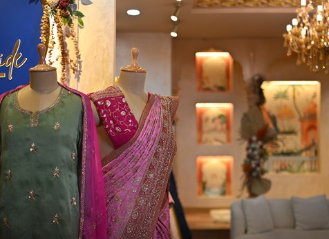 Two mannequins dressed in a sage kurta and a pink saree
