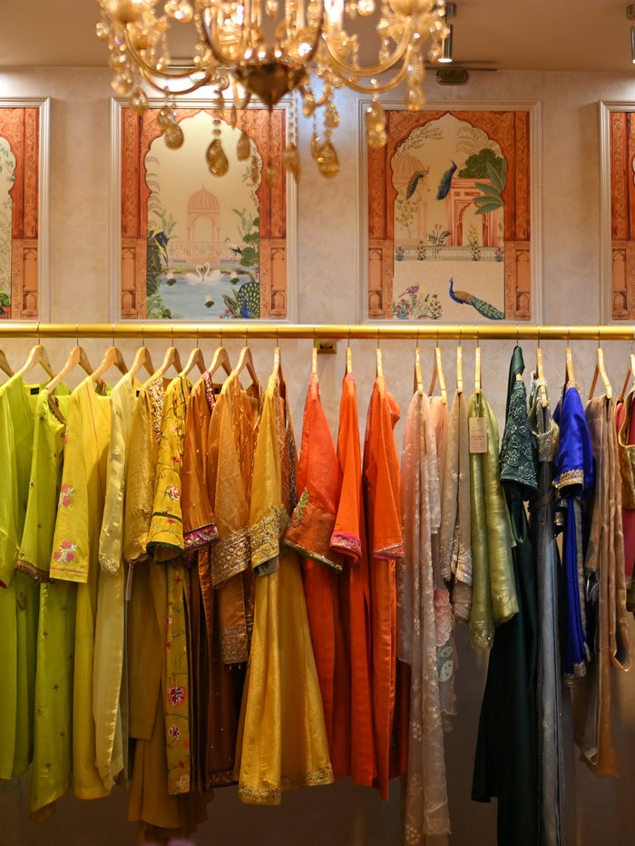 Framed peacock panels above a rail of marigold and coral pieces
