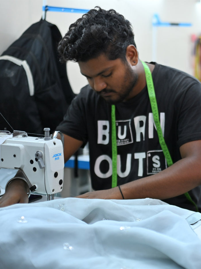 A tailor at his machine in the Summer Bride workroom
